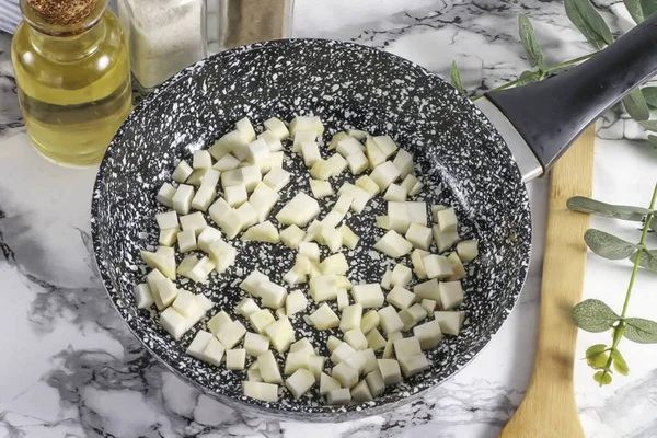 Part of the celery root, peel and rinse. Cut into small cubes or sticks. Heat a frying pan with vegetable oil and pour the celery slices into it.