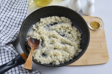 Sebze yağı kuyusu ısıt ve pirinç ekle. Orta sıcakta pişer, sürekli karıştırır, ta ki pilav iyice pişene kadar..