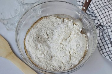 İki fincan buğday unu ve iki fincan çavdar unu ekle. Hamuru yoğurmaya başla. Gerektiğinde yarım bardak buğday unu, bir kaşık yemek kaşığı kullanın..