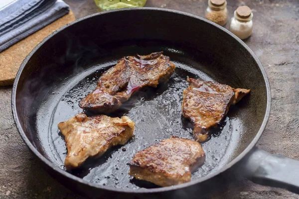 別のフライパンを加熱し 油を注ぐ 肉をレイアウトし 両側に2分間炒める — ストック写真