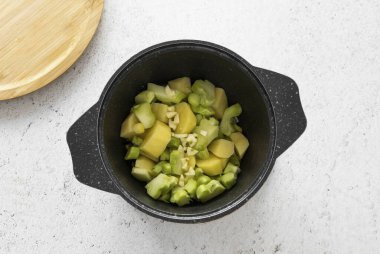 Sonra brokoli sapları, doğranmış patates ve sarımsak ekle. Her şeyi 2-3 dakika daha kaynat..