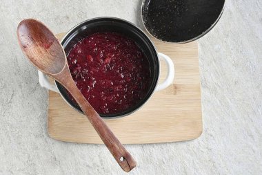 Karışımı kaynat, ısıyı en aza indir, köpüğü çıkar. Böğürtlenler yumuşayana kadar, ahşap bir kaşıkla böğürtlen pişirir, karıştırır ve ezer..