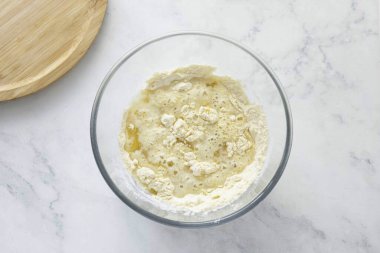 Sebze yağı ekle ve yavaş yavaş su akıtmaya başla..