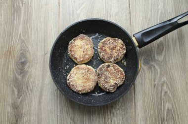 Kızartma tavasına sebze yağı dök ve orta sıcaklıkta ısıt. Peynirli kekleri koy, ısıyı en aza indir ve her iki tarafta da 4-5 dakika kızart. Fazla yağı temizlemek için peynirli kekleri kağıt havluya boşalt..