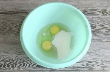 Hamuru peynirli kek için hazırla. 2 yumurta, 100 gram şeker, vanilya ve bir tutam tuzu karıştırın..