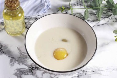 Bir tavuk yumurtasını derin bir kabın içine koyun, aynı yere yağlı süt ve şeker ve tuz ekleyin. Her şeyi 1-2 dakika boyunca döv..