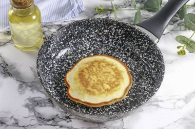 Geniş bir spatulayla nazikçe kaldır ve diğer tarafa çevir. 1-2 dakika daha kızartma.