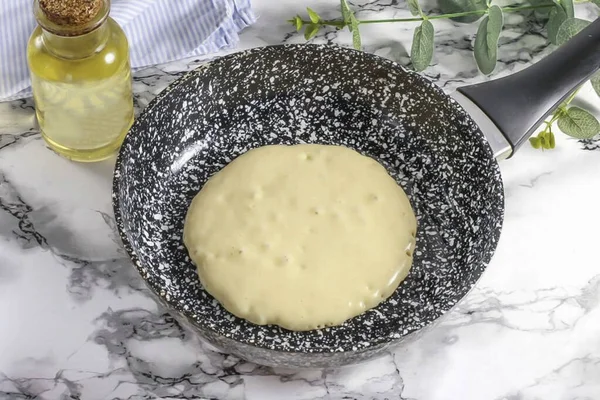 Tavayı önceden ısıt ve altını ilk kez sebze yağıyla yağla. Tavanın ortasına 2 tbsp dök. Sıcaklığı orta seviyeye düşürün. Yüzeyde büyük kabarcıklar görünene kadar krep pişir.