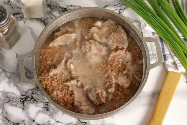 Kaynamış et ve karışımı koy. 8 dakika daha kaynat. Bu süre zarfında, yulaf lapası etin yağını ve suyunu emecek, tadı daha lezzetli ve kadife gibi olacak..