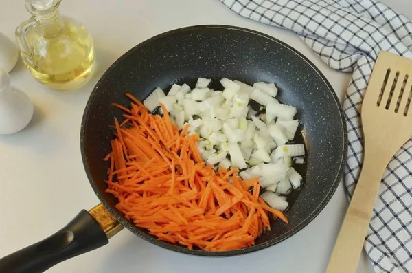 Soğanı küp küp doğra ve havuçları kaba rende rendele. Sebze yağını ısıt ve sebzeleri birkaç dakika kızart..