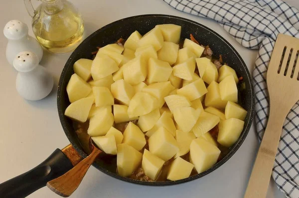 Büyük parçalara bölünmüş patatesleri de ekle, iyice pişene kadar 30 dakika boyunca kapağın altında karıştır ve kaynat..