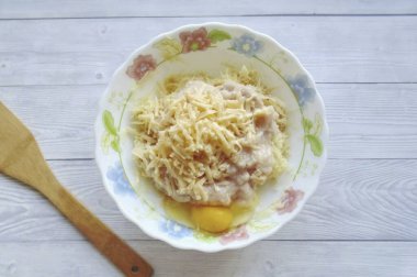 Rendelenmiş peynir ve yumurta ekle. Tadı için tuz ve biber..