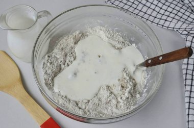 Kefir dök. Hamuru kaşıkla yoğurmaya başla..