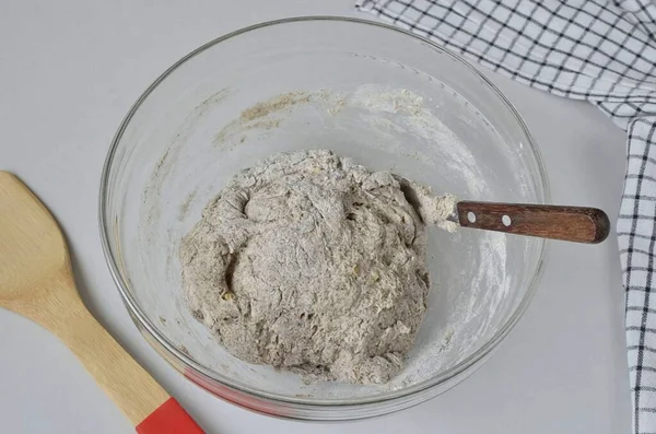 When the flour is all moistened, collect the dough in a lump. Dust the desktop with a little flour, lay out the dough and form a beautiful loaf.
