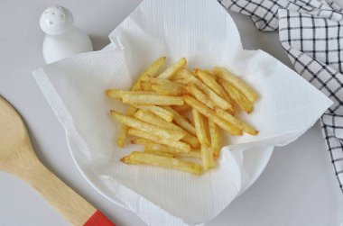 Patatesleri kağıt havluya yerleştirilmiş kaşıkla çıkar, fazla yağın boşalmasına izin ver. Patatesleri tuzla..