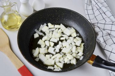 Soğanı soy, çok büyük olmasın ve 2 tbsp 'ye kızart. Yumuşayana kadar sebze yağı.