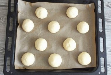 Hafif bir esneme yap. Hamuru on parçaya böl. Her birini fırın kağıdıyla kaplı bir tepside yuvarlayın. 10 dakikalığına çık..