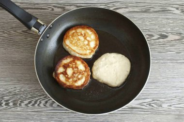 Tavada 3-4 yemek kaşığı ısıt. sebze yağı. Hamuru kaşıkla kepçele ve kaşığın kenarıyla kasenin kenarına doğru kes. Hamuru önceden ısıtılmış tavaya aktarın ve her iki taraf da kahverengileşene kadar orta sıcaklıkta kızartın..