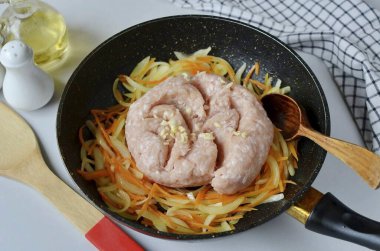 Sebzelere doğranmış tavuk ve sarımsak ekle, biraz tuz ve biber ekle ve kızart, kıyma parçalarını kaşıkla ayır..