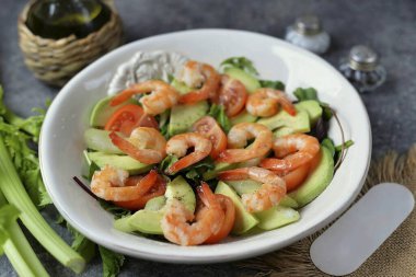 Avokadoyu soy ve çukura at, ince dilimlere ayır, bir sonraki tabakaya dağıt. Kızarmış karidesi avokadonun üstüne koy. Tuz ve biberli tüm malzemeleri mevsim, zeytinyağlı çiseleme ve limon suyu serpiştirme.