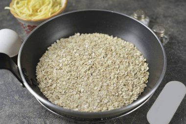 Mısır gevreğini yapışmaz tavaya koy, yulaf ezmesini birkaç dakika kızart ta ki hafif bir fındık aroması gelene kadar..