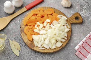 Soğanları ve havuçları keyfi kes, ama çok ince değil. Sarımsağı dilimle..