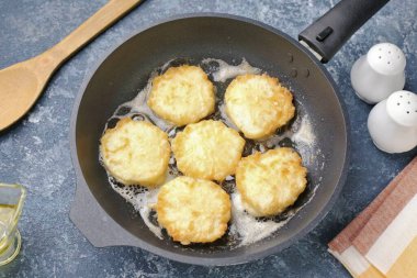 Kızartma tavasını yağla ısıt ve hamuru kaşıkla dağıt. Kahverengiye kadar her iki tarafta da kızartma var. Peynirsiz Syrniki hazır..