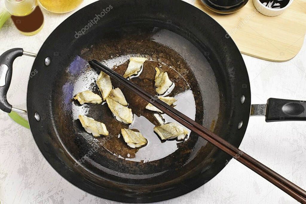 Cut the fish fillet into small pieces and quickly fry in a wok in well-heated vegetable oil.