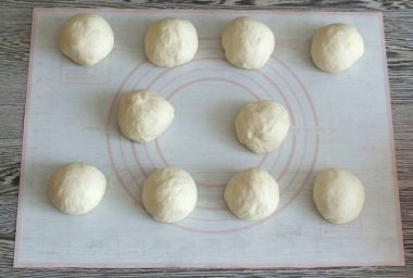 Hamuru eşit parçalara böl. Ortalama olarak, çalışmanın ağırlığı 57-60 gram. Toplayın onları. 5 dakikalığına çık..