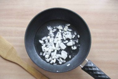 Soğanı soy, yıka ve doğra. Bir tava koyun..