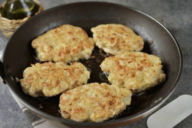 Yığınla yemek kaşığında kıyma alın ve önceden ısıtılmış bir tavaya koyup az miktarda sebze yağına doldurun. Ilımlı ve hatta sessiz sıcaklıkta kızart. Her iki tarafta da 3-4 dakika boyunca. Ta ki güzel, altın sarısı bir kahverengi olana kadar..