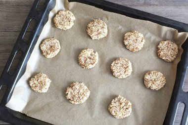 Zaman geçtikten sonra, bir yemek tepsisi alın ve onu pişirme kağıdıyla kaplayın. Buzdolabından bir kase hamur çıkar. Ceviz büyüklüğünde bir parça hamur kopar. İyice püre yap ve sıkı bir top yap. Pastaya karıştır, keki koy.