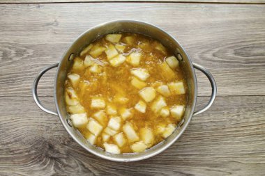 Kavunu kes, çekirdekleri çıkar ve kabuğu kes. Hamuru dilimlere ayır, tencereye koy. Tohum boyunca mango derisini ikiye böl ve çukuru kaldır. Kabuğundan hamuru kes ve parçalara ayır, karpuza ekle. Tavaya şeker dök.