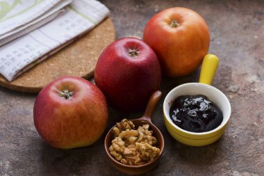 Reçelli fırında elma yapmak için gerekli tüm malzemeleri hazırlayın. Fırını 190 dereceye kadar ısıt..