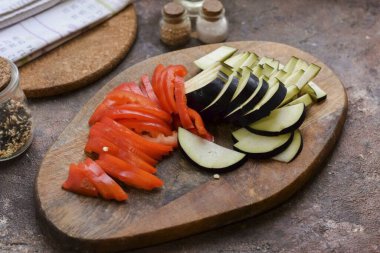 Patlıcanları durula ve kurula, küçük şeritler halinde kes. Tatlı biberleri soy ve durula, dilimlere ayır..