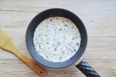 Tavaya krema, mantar, soğan ve sarımsak ekle. Tuz, biber ve üzerine kuru fesleğen serpin. Karıştırır, pişirir, karıştırır, kalınlaştırır, 5-6 dakika..