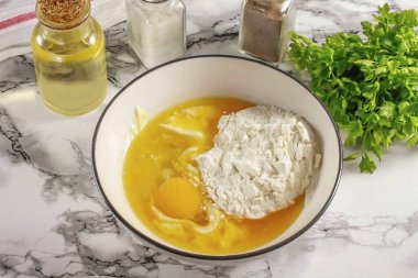 Tereyağını mikrodalgada ya da su banyosunda erit ve hafifçe soğut. Yağ kabına bir yumurta kır, tuz ekle ve döv. Buğday unu ekle ve sert bir kısayol hamur işi yoğur. Buzdolabına askılı film ve yerleştirme ile kapla..