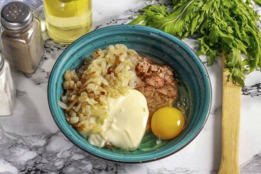 Kaynamış balık hamurunu öğütüp derin bir konteynıra koyun. Kızarmış soğan, yağlı ekşi krema ve tuz ekle. Balık ya da sebze için baharat ekleyebilirsiniz. Karıştır.