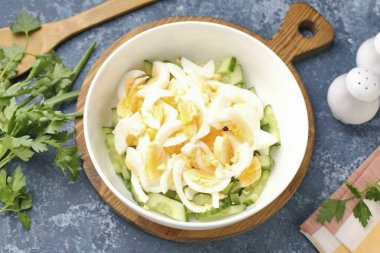 Yumurtaları soy ve küçük parçalara böl. Salatalığa ek.