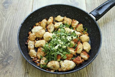 Çalkala ve kaba bir şekilde kişniş doğra, sarımsağı ince ince doğra ve hindi ve fındıklı bir tavaya koy. Her şeyi karıştır ve ısıdan uzak dur. Hindiyi kişniş ve kaju ile paylaştırın ve servis yapın..