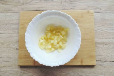 Ananası kavanozdan çıkar ve istediğin gibi ince ince doğra. Salata kasesi koy..