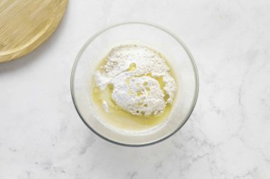 Sonra un, sebze yağı, vanilya ve kabartma tozu ekleyin. Her şeyi karıştır. Hamurun yoğunluğu yoğun ekşi kremaya benzemeli..