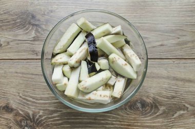 Patlıcanı yıka, uçlarını kes ve büyük şeritler kes. Sebzeyi salata kasesine koy, tuz ve soğuk suyla kapla. 20 dakika ayrıl, sonra boşalt, durula ve suyu tamamen boşalt..