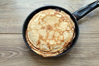 Bake thin pancakes from the whole dough until golden brown on both sides. Cover pancakes and let cool completely. clipart