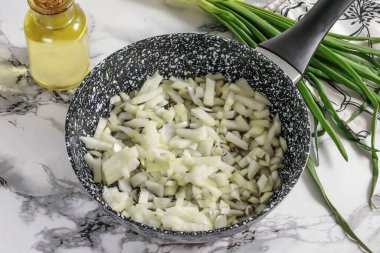 Bu sefer soğanları soy ve suda durula. Küçük küplere böl. Tavada 3-4 dakika kadar sebze yağında kızartılmış soğan dilimleri.