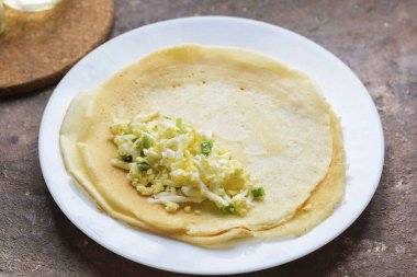 Her gözlemenin üzerine biraz yumurta ve soğan koy..