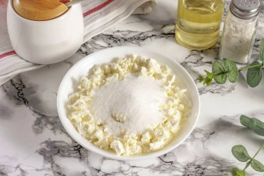 Elma dilimlerini 20-30 dakika soğut. Bu sefer, süzme peynirle granüllü şekeri karıştır. Eğer kuruysa, biraz ekşi krema ya da kefir koyun..