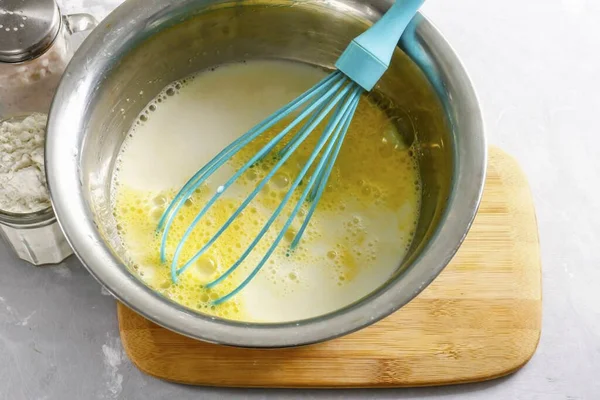 Tavuk yumurtalarını derin bir kaba koy, içine süt dök, şeker ve tuz ekle. 2-3 dakika boyunca çırpıcıyla her şeyi döv..