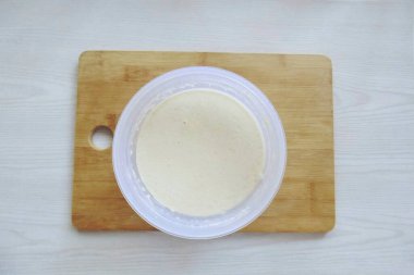 Karıştırırken, yavaş yavaş ellenmiş unu da ekle. Homojen, sıvı, yumru hamuru olmayan bir şey. Sonunda, ayçiçeği yağı dök ve karıştır..