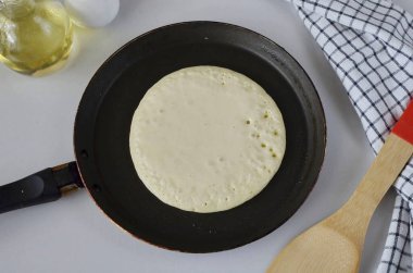 Tavayı önceden ısıt, eğer yapışkan değilse, yağlamana gerek yok. Bir kepçe hamur dökün, kendi kendine yayılacaktır, esnetmenize ya da sürmenize gerek yoktur. Yayıldıkça, kabarcıklar görünene kadar böyle kızarsın. Yangın biraz fazla ilerlemiş.